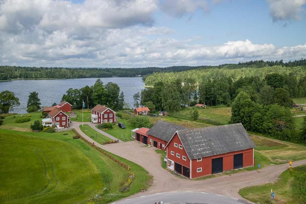 een luchtzicht op een boerderij met een huis en een meer bij Snokebo Gård in Vimmerby