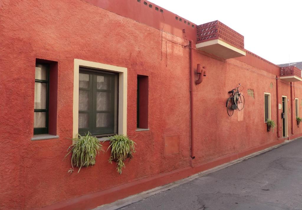 a red building with plants on the side of it at beb "Ziu Antoi e Zia Srivia" in Sestu