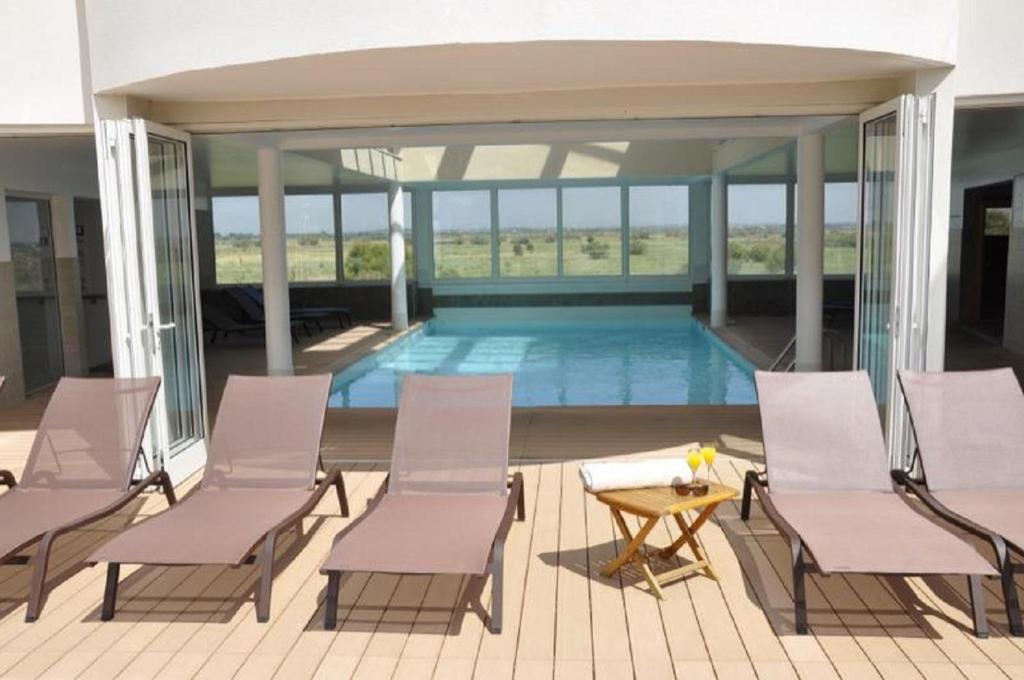 un patio avec des chaises et une piscine dans l'établissement Résidence Hôtelière Natureva & Spa, au Cap d'Agde