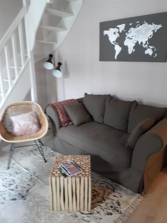 un salon avec un canapé et une table dans l'établissement Appartement cosy dans le centre de Honfleur, à Honfleur