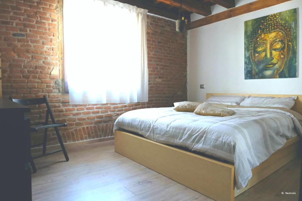 - une chambre avec un grand lit et un mur en briques dans l'établissement Vivi Vicenza, à Vicence