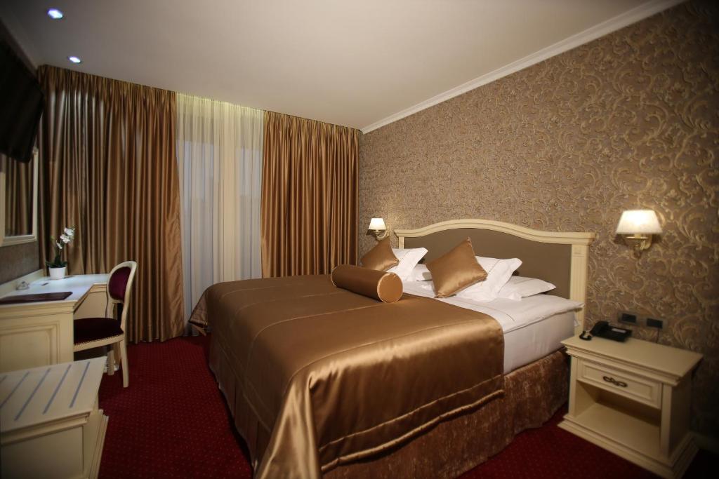 Pokój hotelowy z łóżkiem i biurkiem w obiekcie Grand Hotel & Spa Tirana w Tiranie