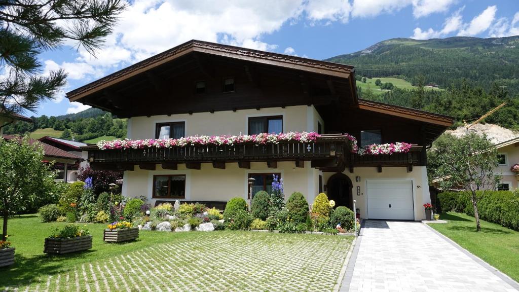 una casa con flores en el patio delantero en Gästehaus Margareta en Wald im Pinzgau