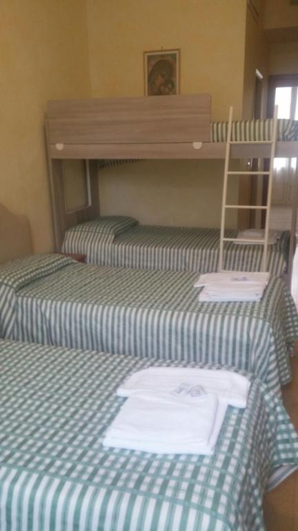 two beds in a room with a bunk bed at Ostello Villa Monte Mario in Rome
