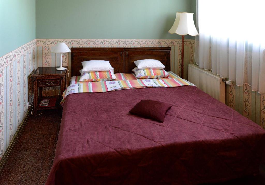 a bedroom with a large bed with a purple blanket at Birinu Pils in Bīriņi