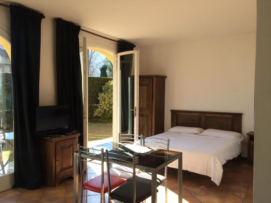 una camera con letto e tavolo in vetro di Appartamenti Ferrari Residence a Cannobio