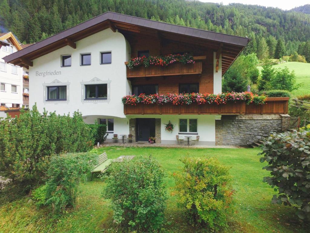 a large white house with flowers on the balcony at Haus Bergfrieden in Kaunertal