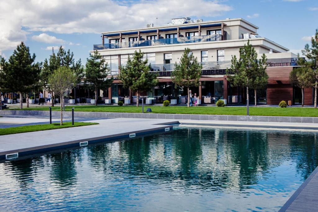 um edifício com piscina de água em frente a um edifício em Riviera Zoloche Resort & Spa em Vishenki