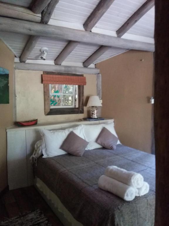 a bedroom with a large bed with a wooden ceiling at Casa da Ro in Praia do Rosa