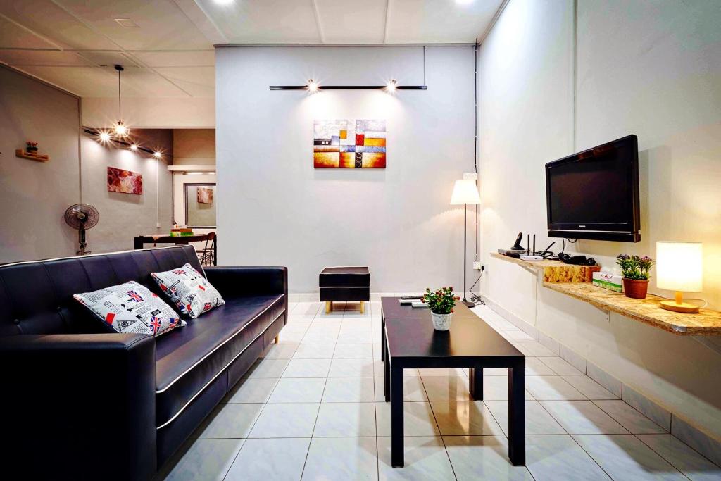 a living room with a couch and a tv at Home Art 103 in Ipoh