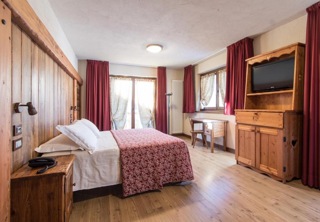 a hotel room with a bed and a television at Limone Palace Aparthotel in Limone Piemonte