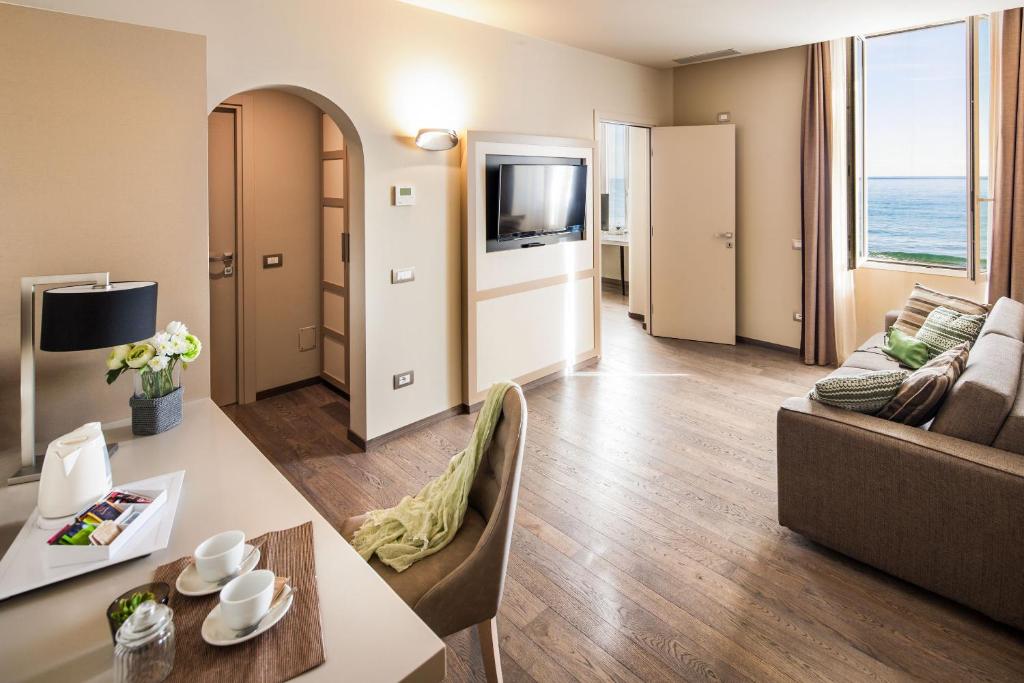 salon z kanapą i stołem w obiekcie Hotel Savoia w Alassio