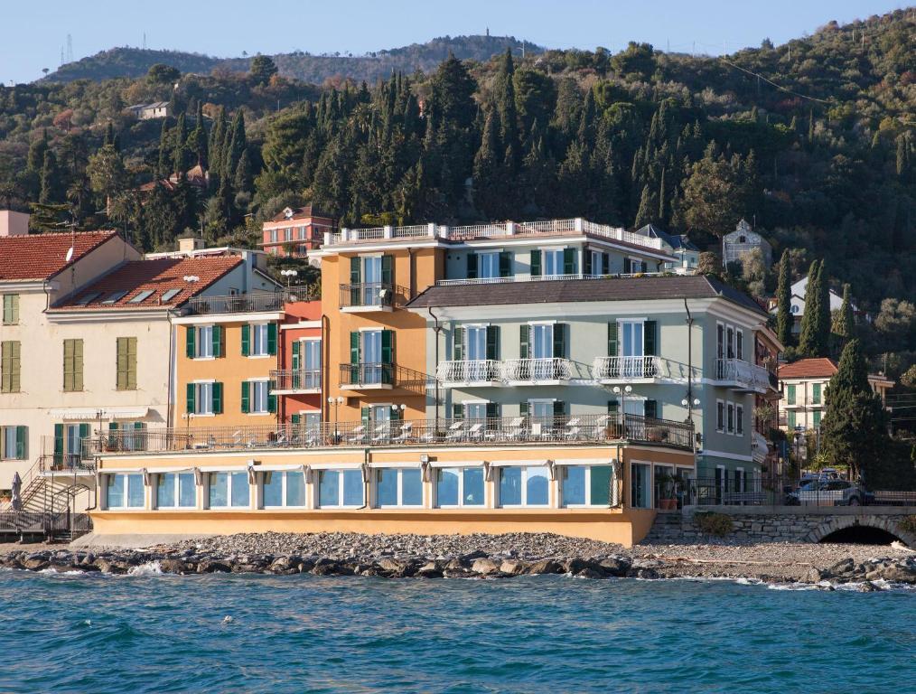 a large building on the shore of the water at Hotel Savoia in Alassio