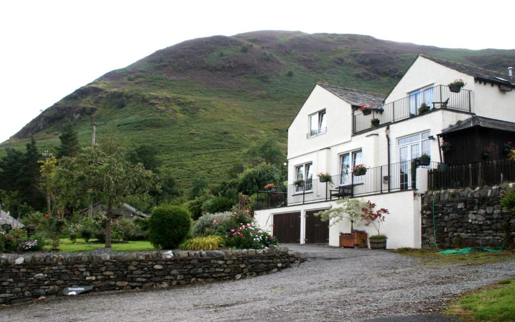 a white house with a hill in the background at StoneyGill A in Keswick