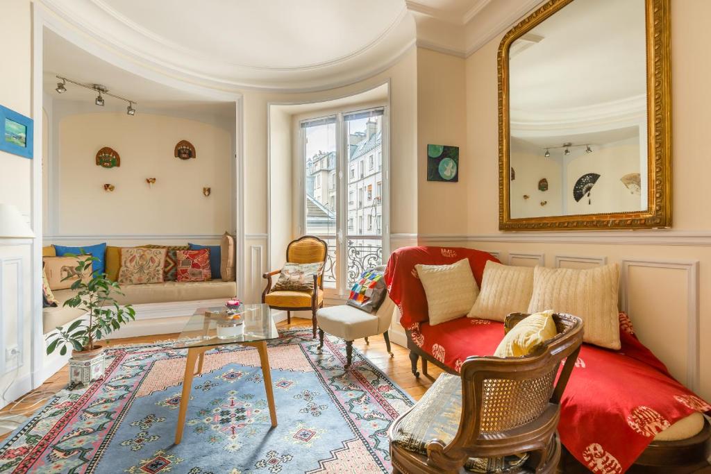 ein Wohnzimmer mit einem roten Sofa und Stühlen in der Unterkunft Veeve - Overlooking the Seine on Ile de la Cité in Paris