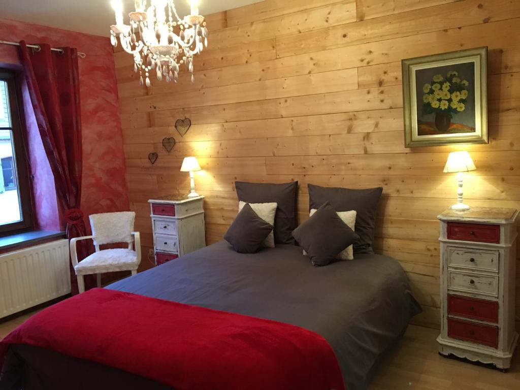 um quarto com uma cama grande e uma parede de madeira em Les appartements d'estelle em La Petite-Pierre
