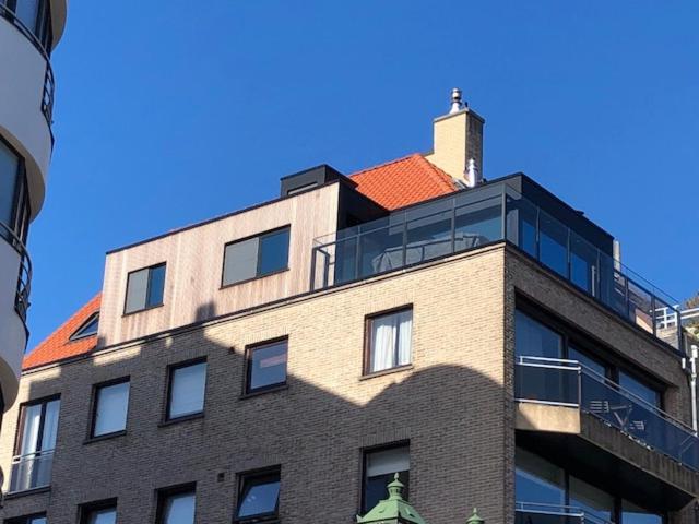 un edificio alto de ladrillo con techo rojo en Soetkin, en Knokke-Heist