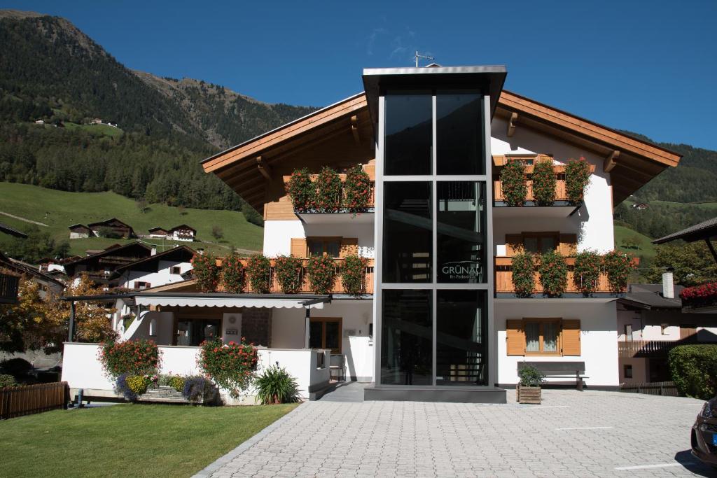 a building with potted plants on the side of it at Garni Grünau in San Martino