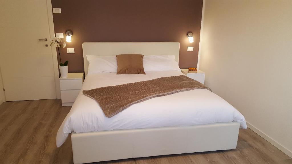1 dormitorio con 1 cama blanca grande con sábanas blancas en Altebas, en Nogaredo di Prato