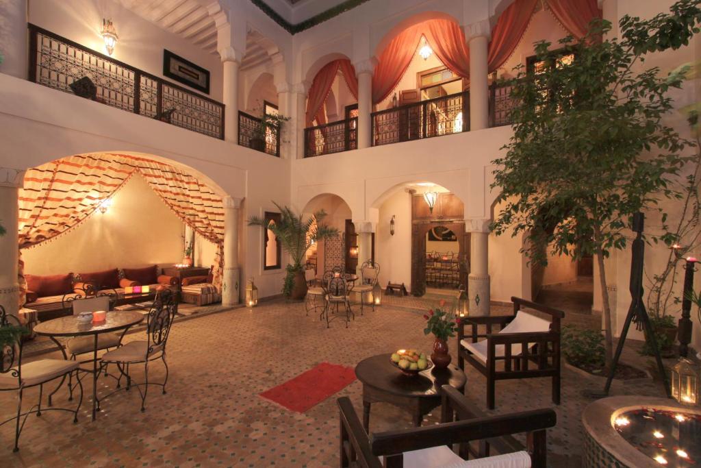 una grande stanza con tavoli e sedie in un edificio di Riad Cannelle a Marrakech