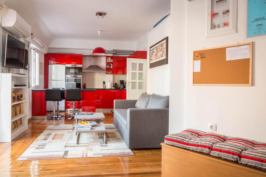a living room with red cabinets and a gray couch at Martin&rsquo;s Akropolis loft in Athens