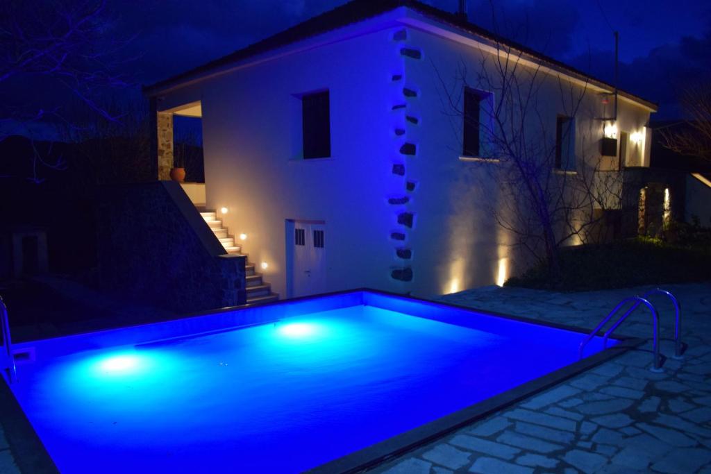 a swimming pool with blue lights in front of a house at Villa Vlatos in Vlátos