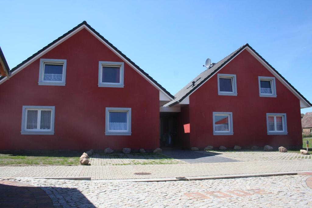 米羅的住宿－Schwantje Mirow 6a，两座红色房子,前面有泰迪熊