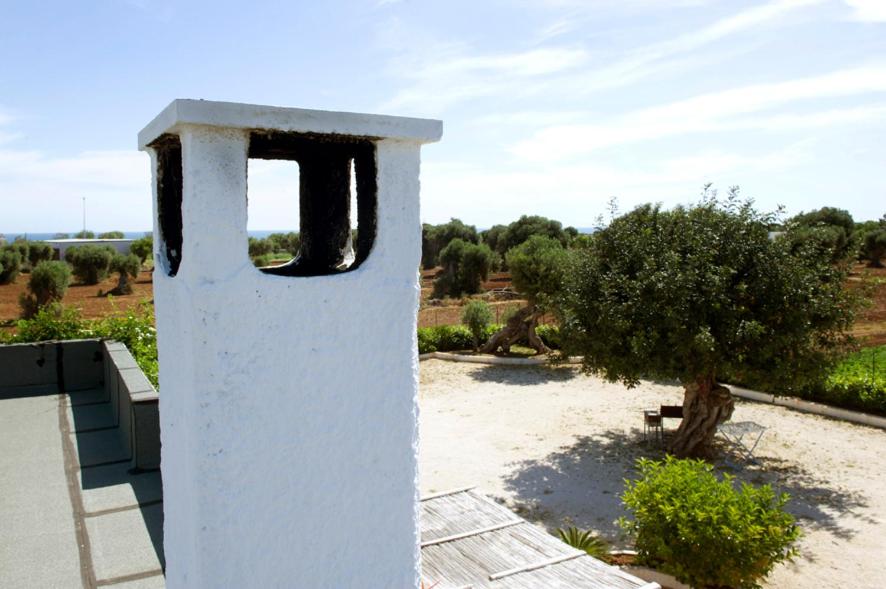 a white building with a window on top of a field at case per vacanze torre incina in Polignano a Mare