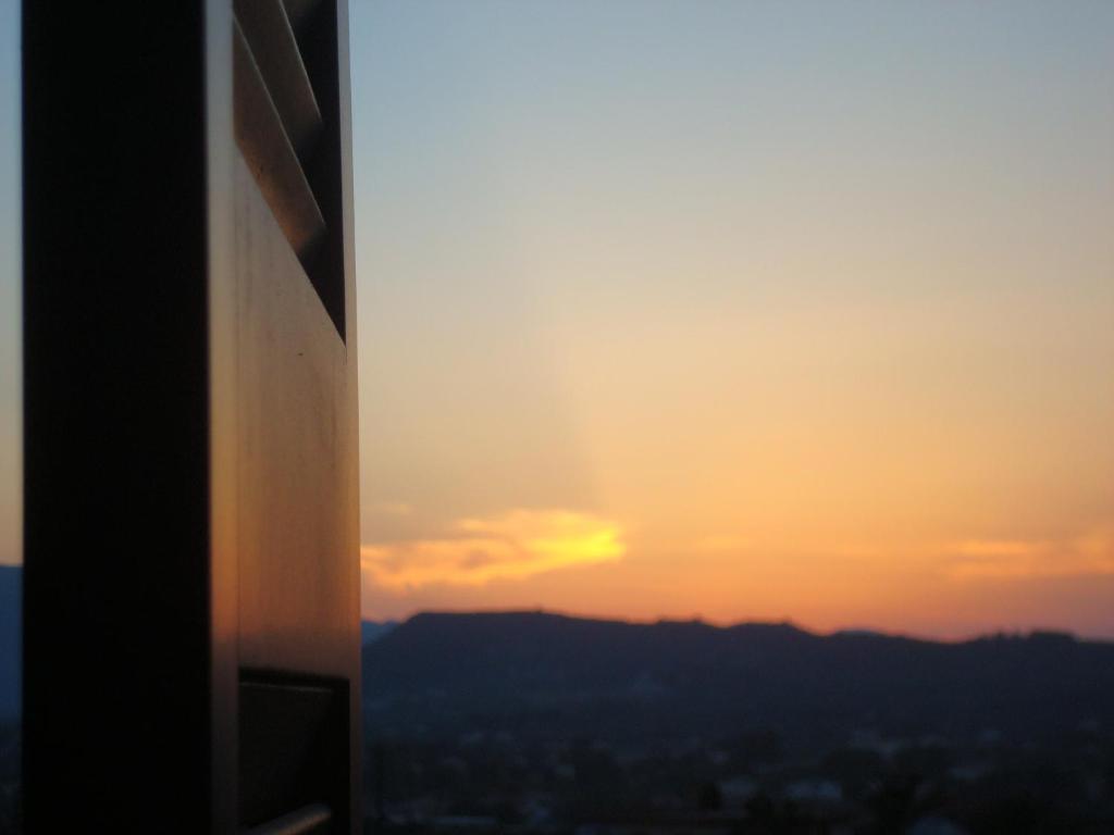 a sunset seen from a window of a building at Villa Conifera in Zakynthos Town