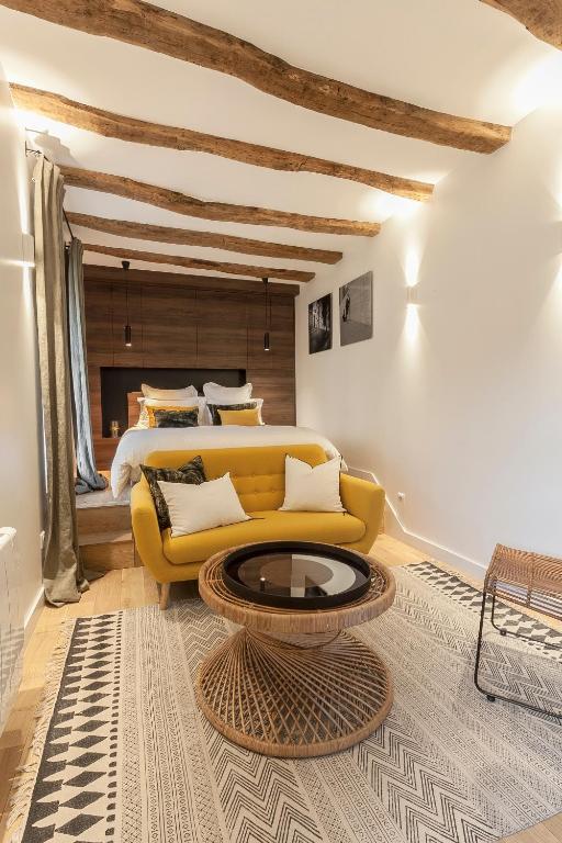 a bedroom with a yellow couch and a bed at Maison TANDEM in Cluny