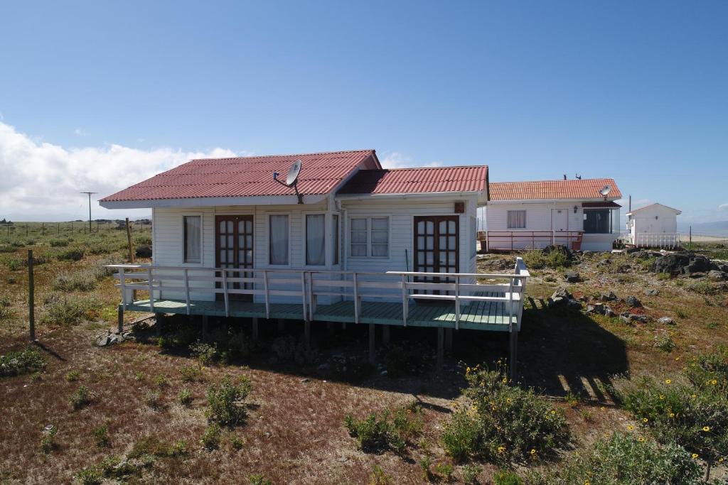 una casa con techo rojo en un campo en Las Hualas, en Punta de Choros