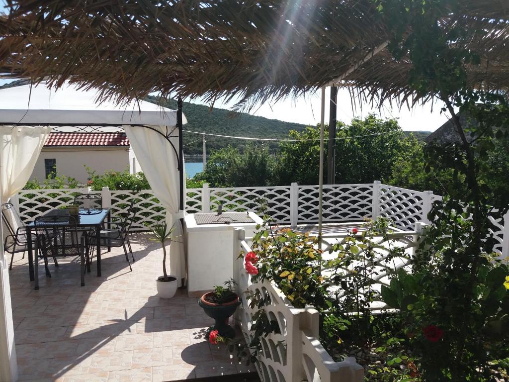 a patio with a table and chairs and a white fence at Adorable Summer house by the sea in Zapuntelo