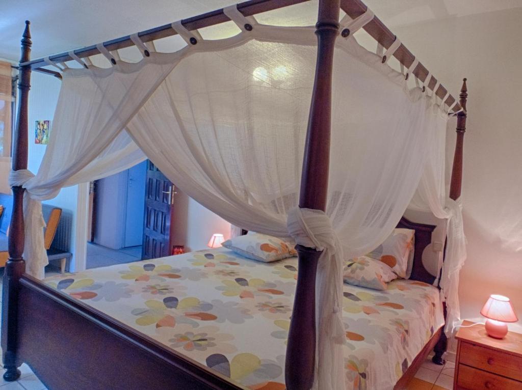 a bedroom with a bed with a canopy at Le Parc aux Orchidées in Pointe-Noire