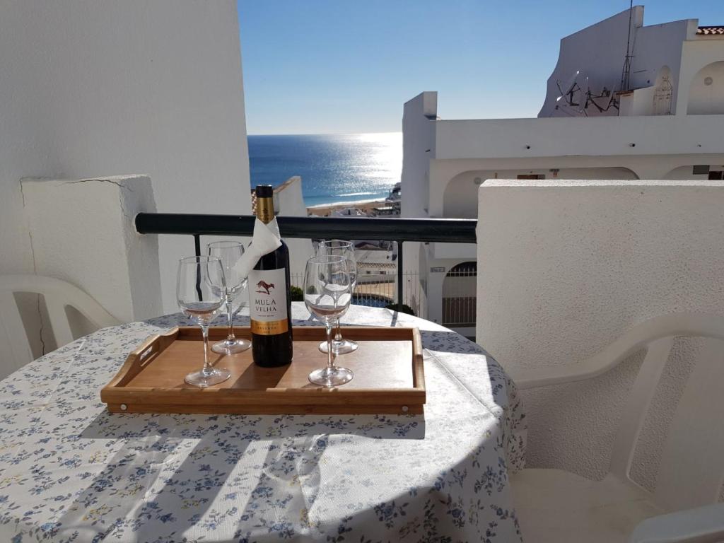 a bottle of wine sitting on a table with glasses at Apartamento Correia in Albufeira