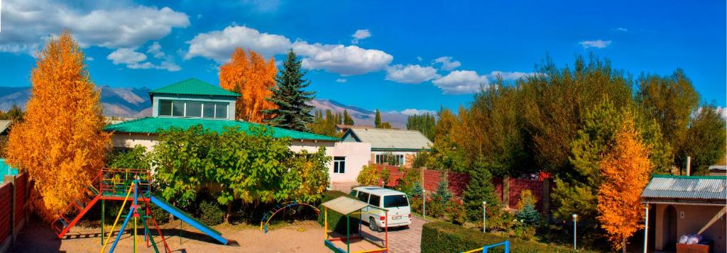 une aire de jeux en face d'une maison avec toboggan dans l'établissement Tian-Shan Guest House, à Balykchy