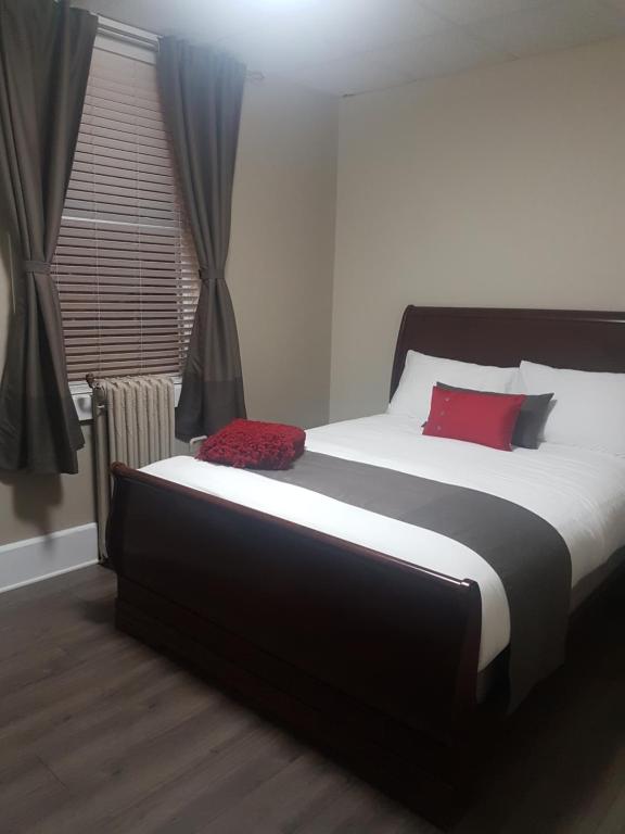 a bedroom with a large bed with a red pillow at 1-Bedroom Cozy Suite #23 by Amazing Property Rentals in Gatineau