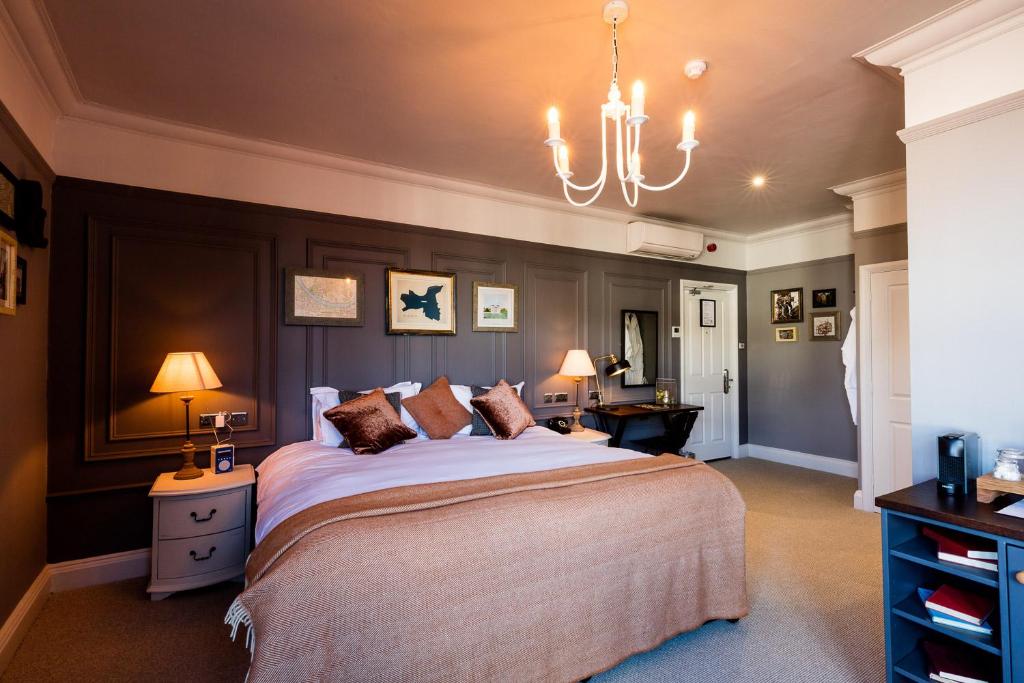 Un dormitorio con una cama grande y una lámpara de araña. en The Brewers Inn, en Londres