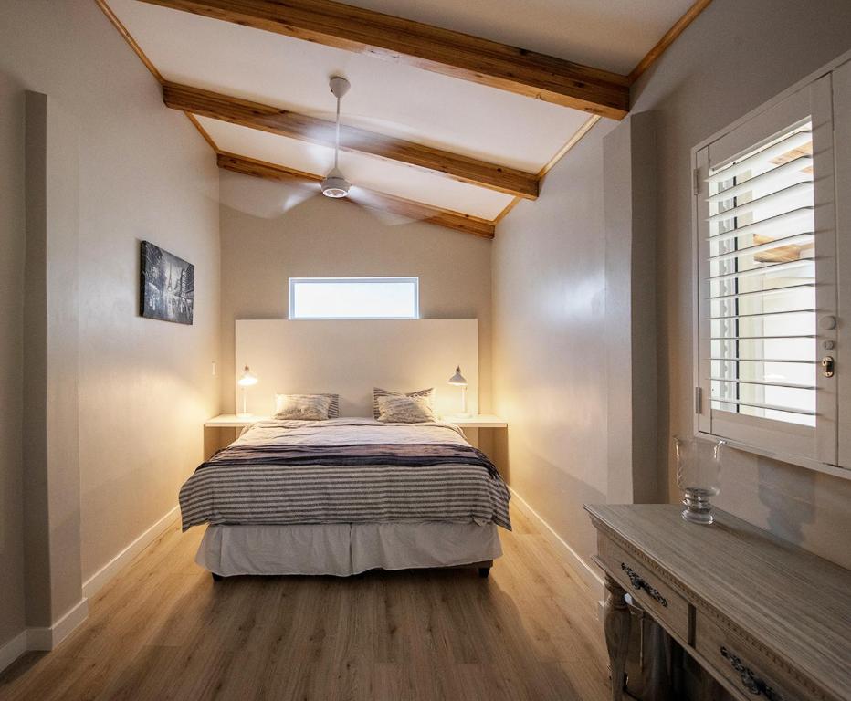 - une chambre avec un lit et un ventilateur de plafond dans l'établissement Umhlanga Lodge, à Durban