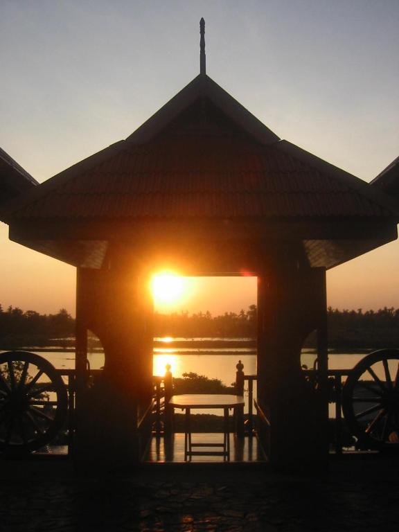 a gazebo with a bench in front of a sunset at Hidden Holiday House in Ban Don Faek