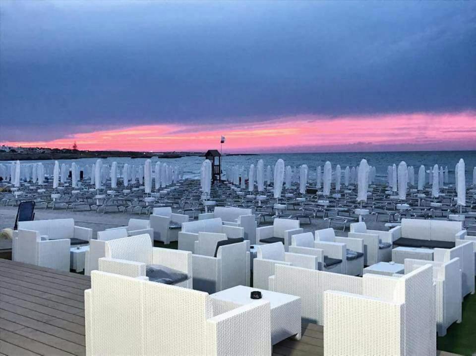サン・フォカにあるCase Vacanze Eurogardenの白い建物と海の景色を望むビーチの景色