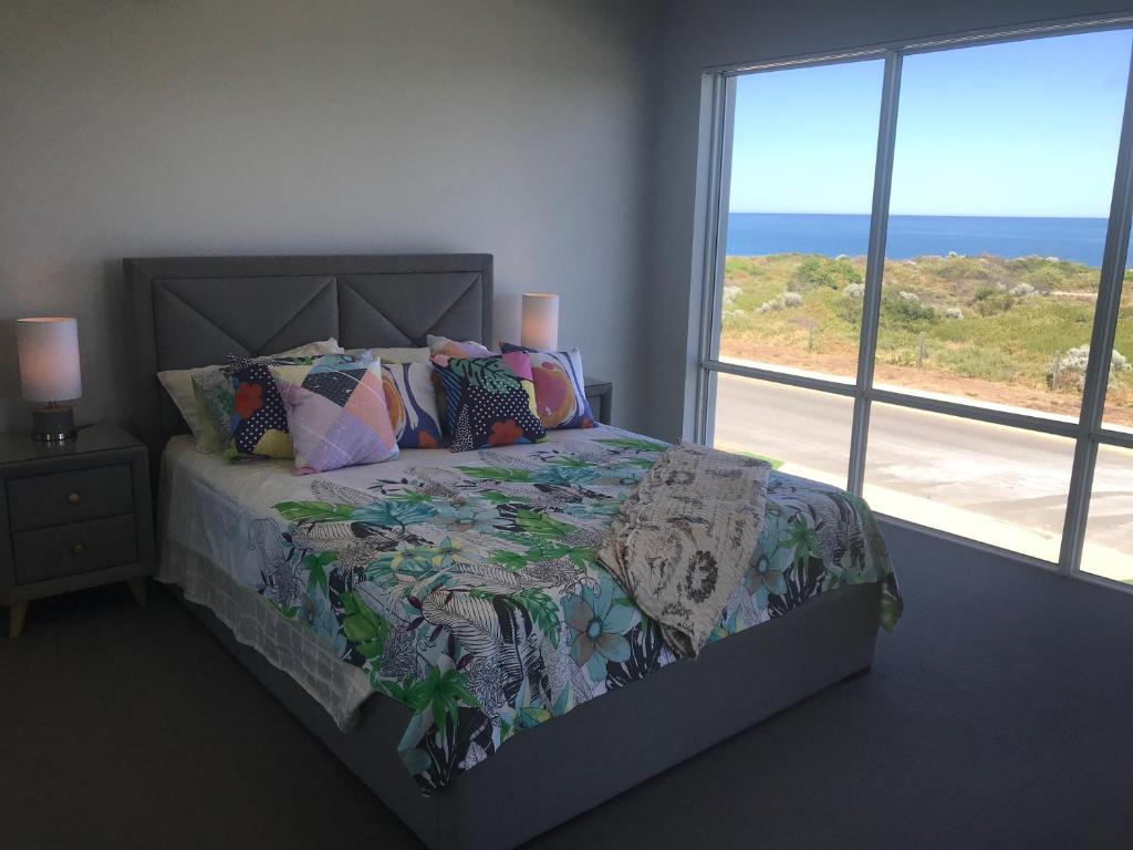 a bedroom with a bed with a view of the ocean at Beach House at SeaScapes.. in Mandurah