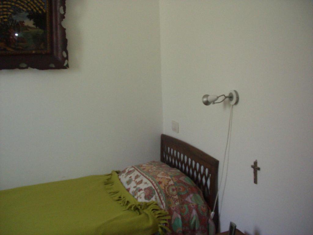 ペーザロにあるBarbaraのベッドルーム1室(壁に十字架付きのベッド1台付)