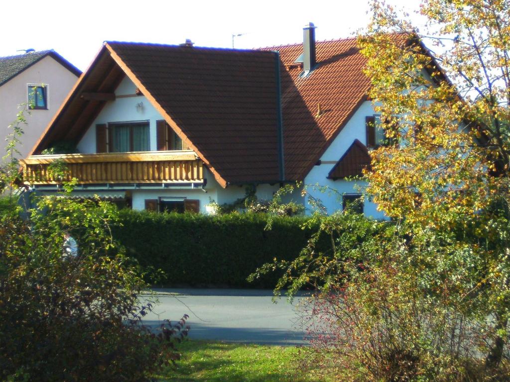 une maison blanche avec un toit marron dans l'établissement Ferienwohnung Schütz, à Hirschaid