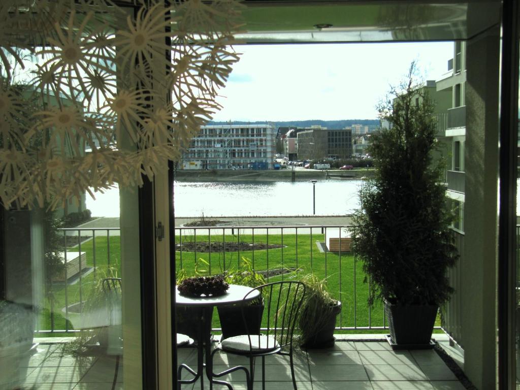 a balcony with a table and chairs and a view of the water at Ferienwohnung Lac Konstanz in Konstanz