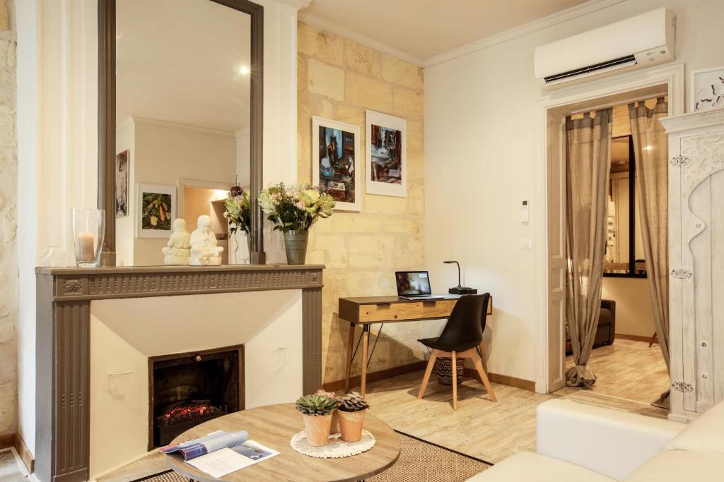 a living room with a fireplace and a desk at Nona Home Bordeaux in Bordeaux
