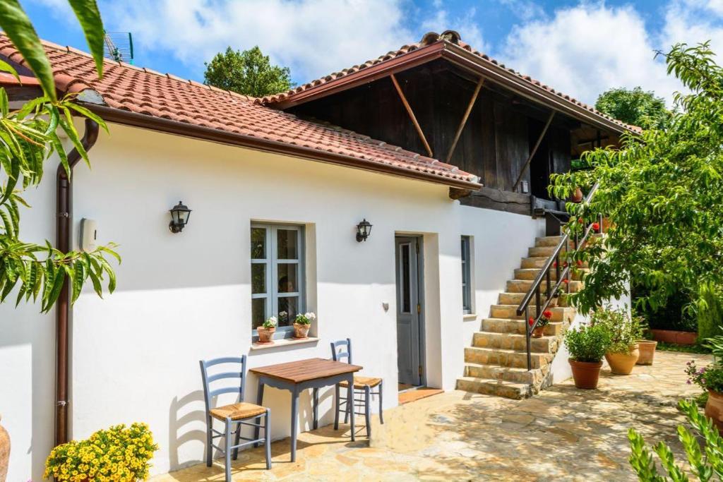 a white house with a table and chairs at Casa Candelas in Lugo de Llanera