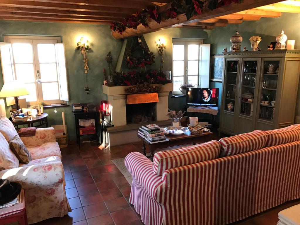 a living room with two couches and a fireplace at Casa Colli Piacentini in Pianello Val Tidone