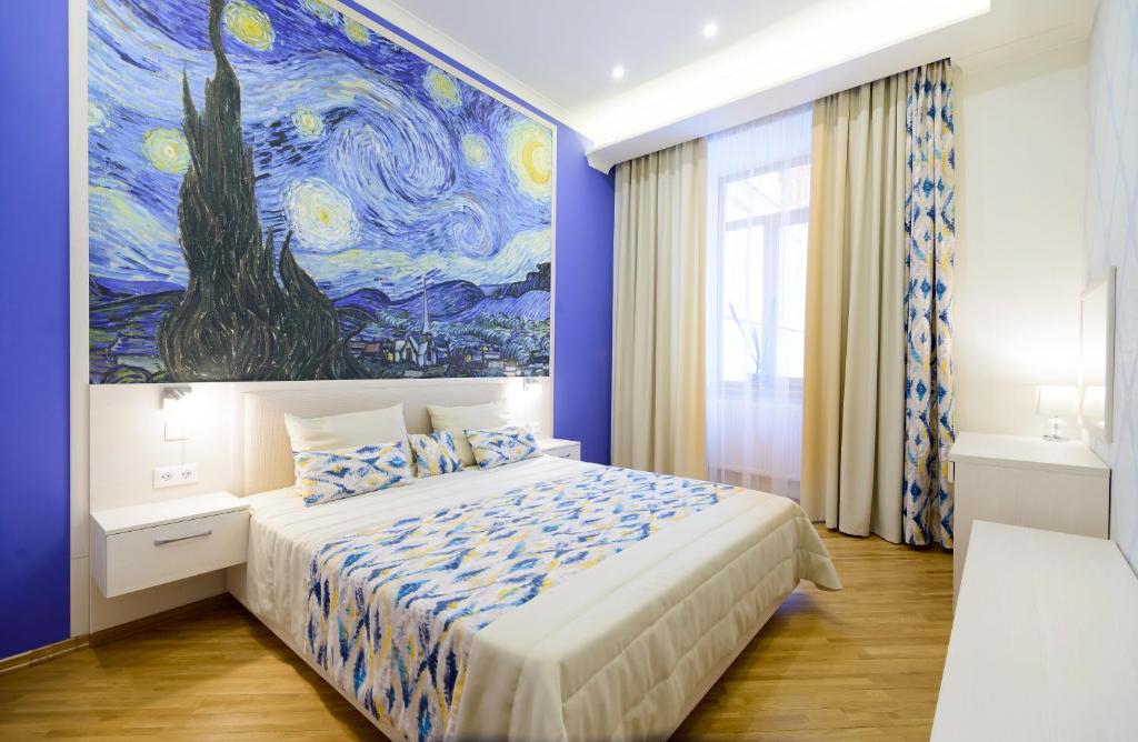 a bedroom with a bed with a painting on the wall at VIP апартаменти Ван Гог на площі Ринок in Lviv