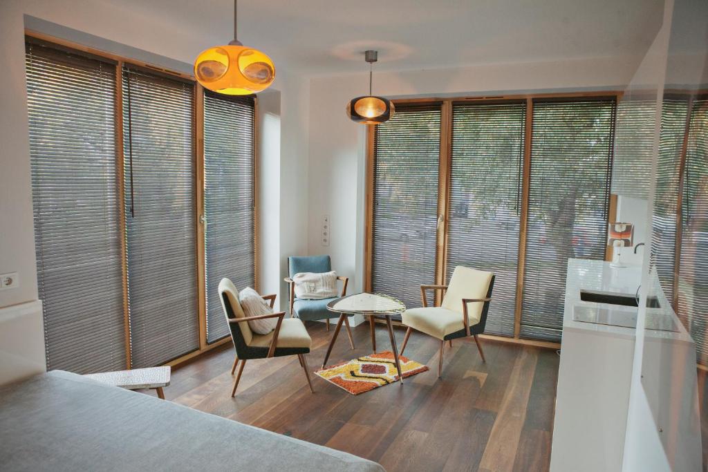 ein Wohnzimmer mit einem Tisch, Stühlen und Fenstern in der Unterkunft Baltic Beach Retreat in Nida