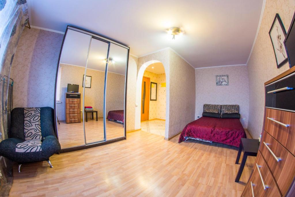 オムスクにあるRENT-сервис Apartment Serovaのベッドルーム(ベッド1台、大きな鏡付)